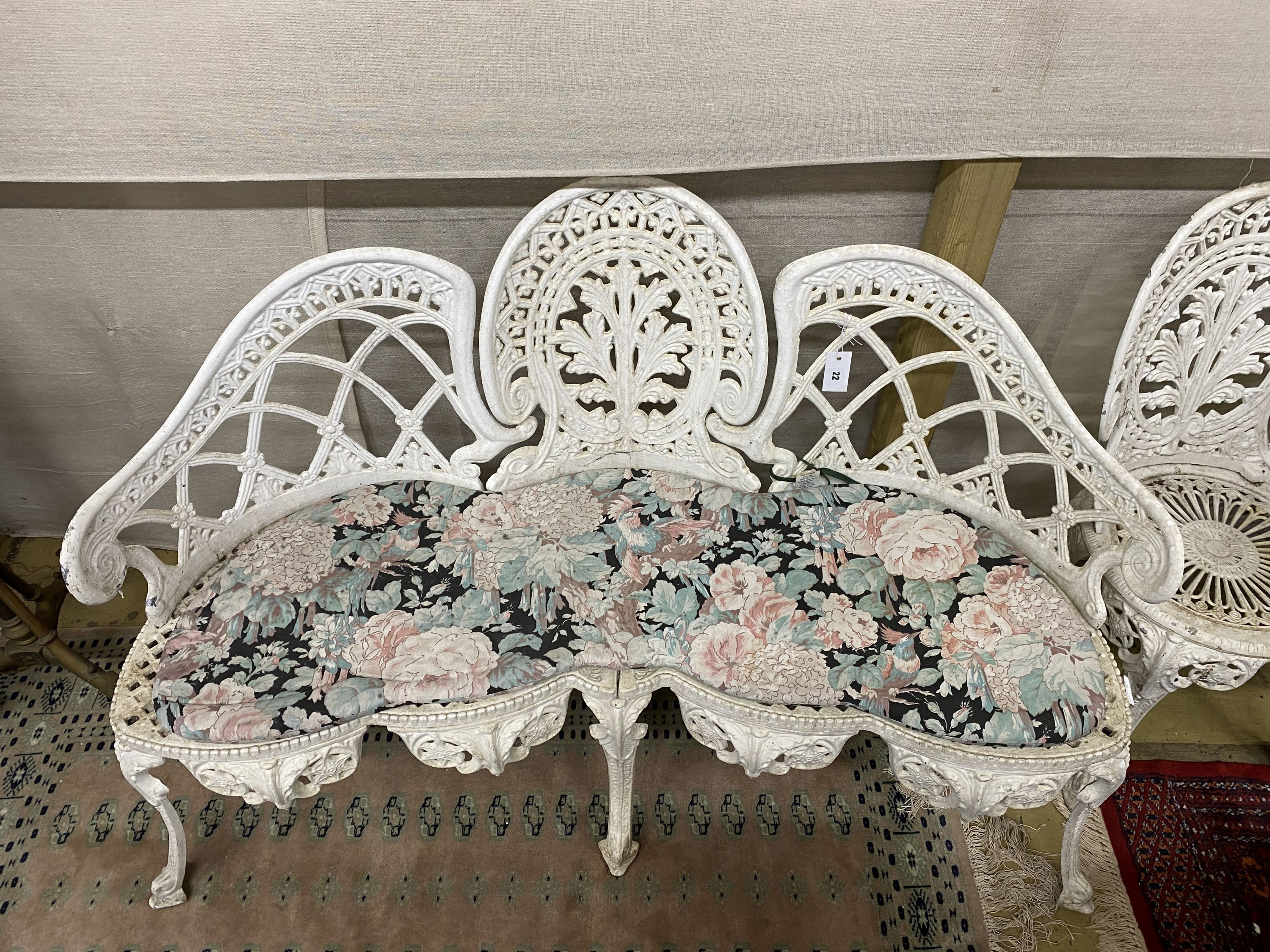 A five piece white painted metal alloy garden suite comprising two benches, length 137cm, pair of chairs and a table, length 141cm